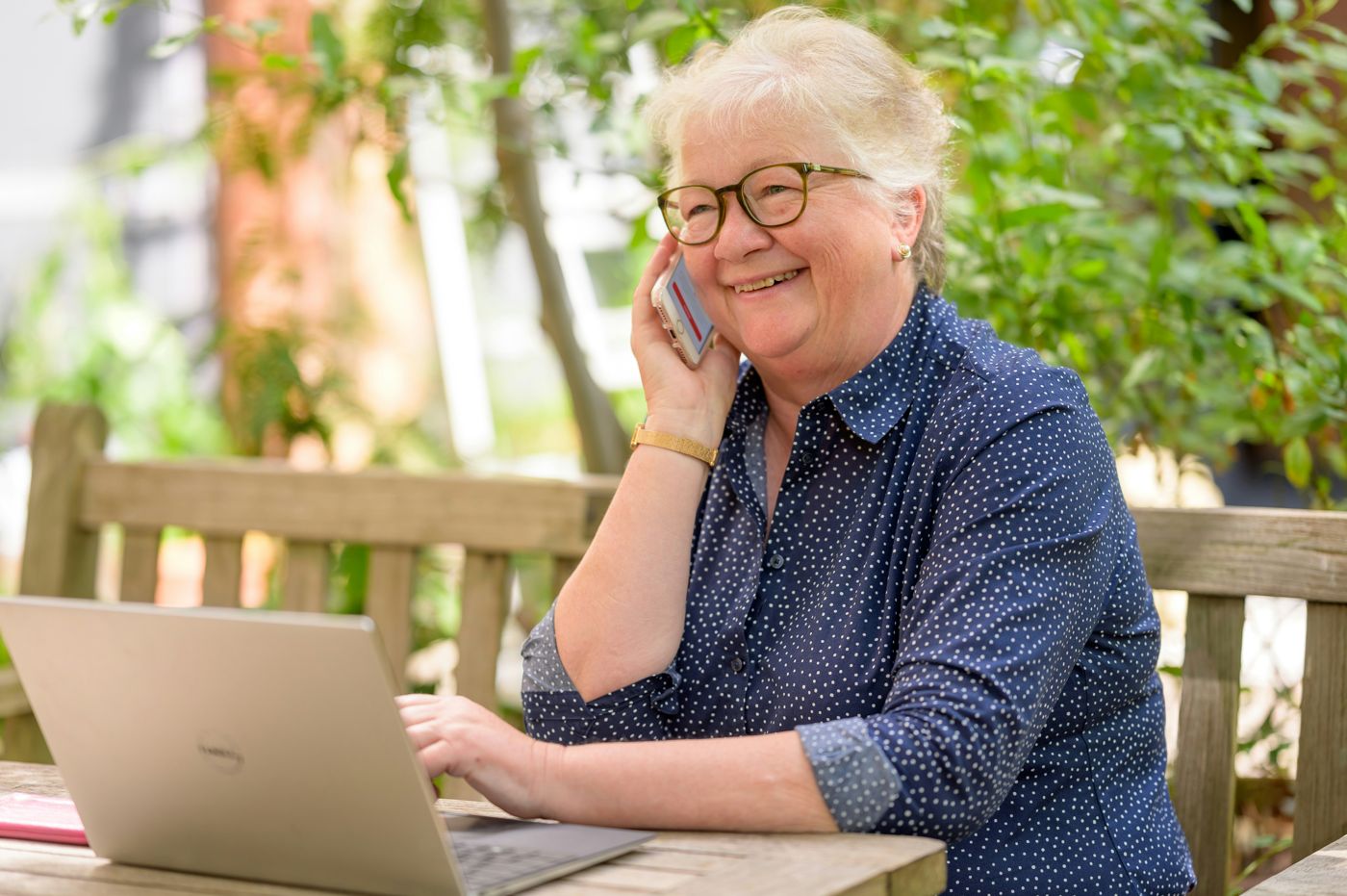 Smiling older woman talking on her phone outdoors