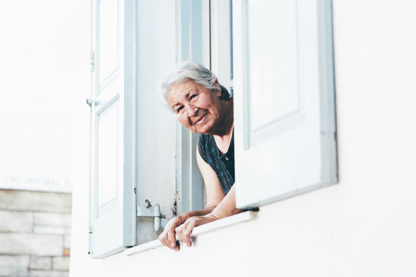 Smiling older woman leaning out of her window